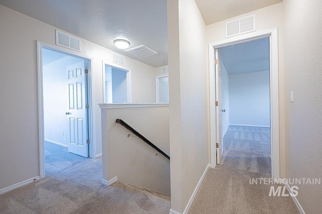 13513 Palm Bch, Caldwell, ID 83607 - hallway featuring an upstairs landing, carpet, and a textured wall