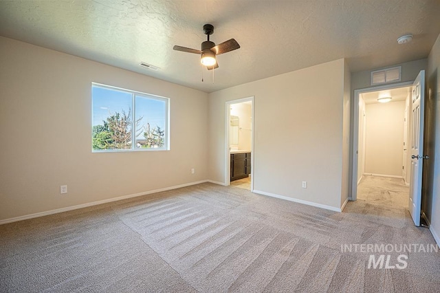 13513 Palm Bch, Caldwell, ID 83607 - unfurnished bedroom featuring a textured ceiling, light carpet, ensuite bathroom, and a ceiling fan