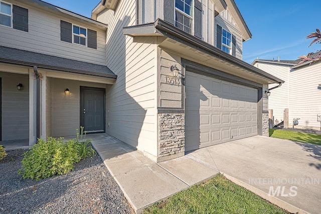 13513 Palm Bch, Caldwell, ID 83607 - view of exterior entry featuring an attached garage, driveway, and stone siding