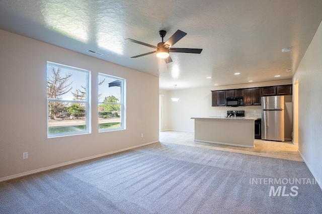 13513 Palm Bch, Caldwell, ID 83607 - unfurnished living room featuring light carpet, a ceiling fan, recessed lighting, and a textured ceiling