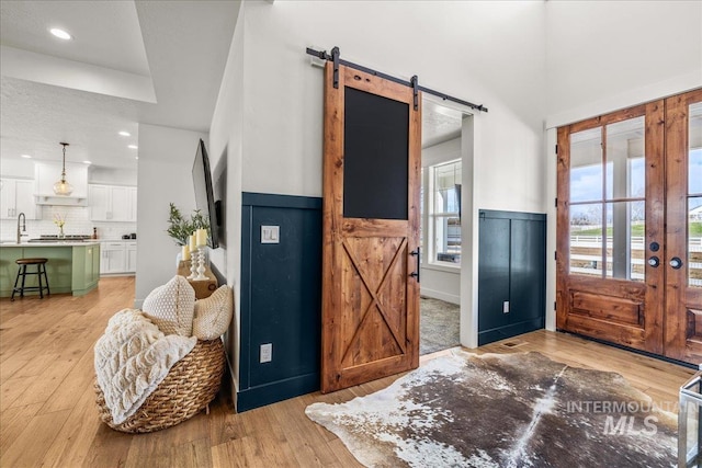 10935 Purple Sage Rd, Middleton, ID 83644 - entrance foyer featuring recessed lighting, a barn door, light wood-style floors, and wainscoting