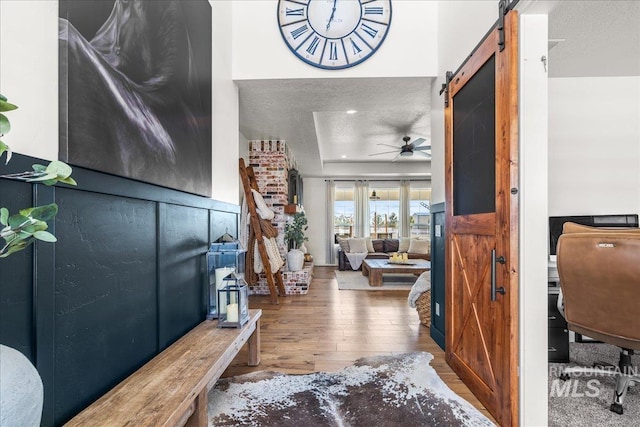 10935 Purple Sage Rd, Middleton, ID 83644 - foyer entrance with a barn door, hardwood / wood-style flooring, a ceiling fan, and a textured ceiling