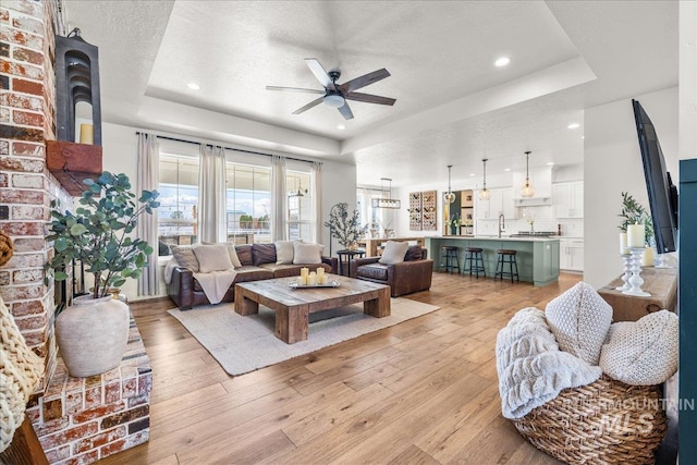 10935 Purple Sage Rd, Middleton, ID 83644 - living area with a tray ceiling, a textured ceiling, ceiling fan, and light wood finished floors