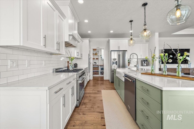 10935 Purple Sage Rd, Middleton, ID 83644 - kitchen featuring high end appliances, white cabinetry, light wood-style flooring, an island with sink, and green cabinets