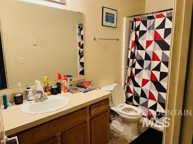 full bathroom with vanity, a shower with shower curtain, and toilet