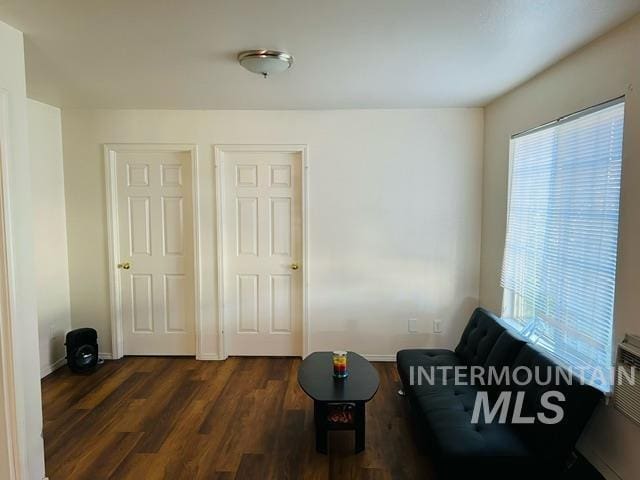 unfurnished room featuring plenty of natural light, baseboards, and dark wood-style flooring