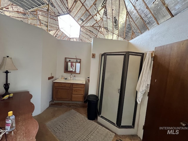 full bathroom featuring concrete floors, vanity, a high ceiling, and a shower stall