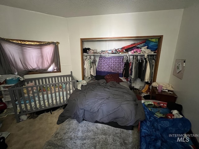 bedroom with a closet, carpet flooring, and a textured ceiling