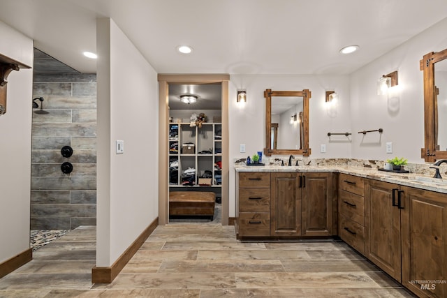 bathroom featuring wood-type flooring, vanity, and walk in shower