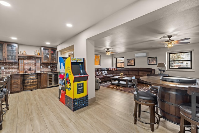 kitchen featuring plenty of natural light, a wall mounted AC, wine cooler, and light wood-type flooring