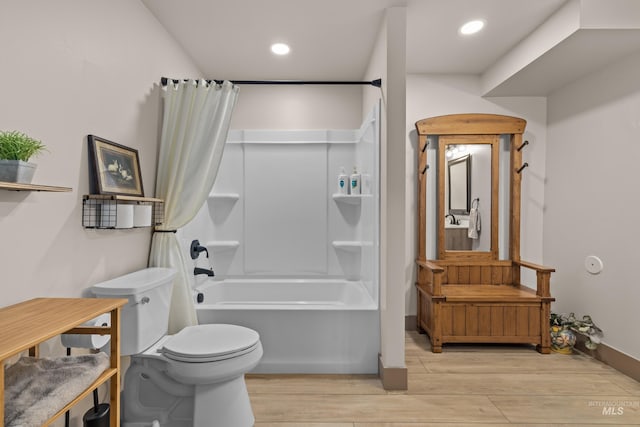 bathroom with wood-type flooring, shower / bath combination with curtain, and toilet