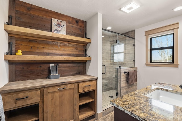 bathroom featuring vanity, a wealth of natural light, and a shower with shower door