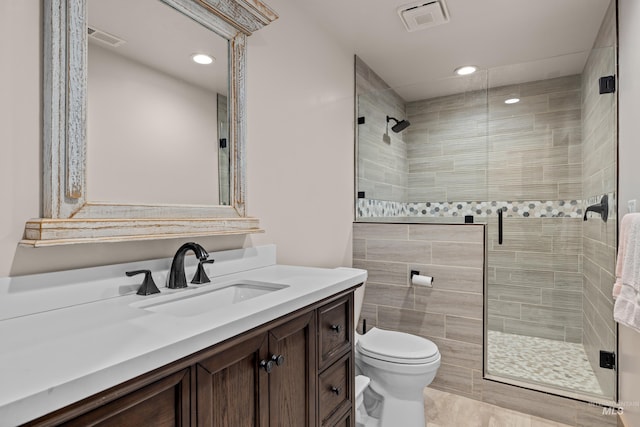 bathroom featuring vanity, toilet, and walk in shower