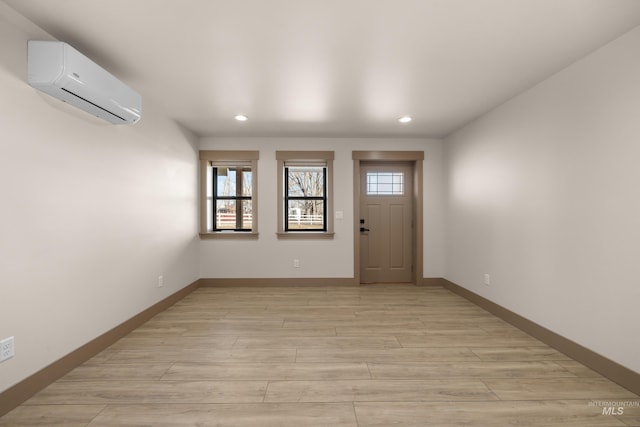 entrance foyer featuring a wall mounted air conditioner and light hardwood / wood-style flooring