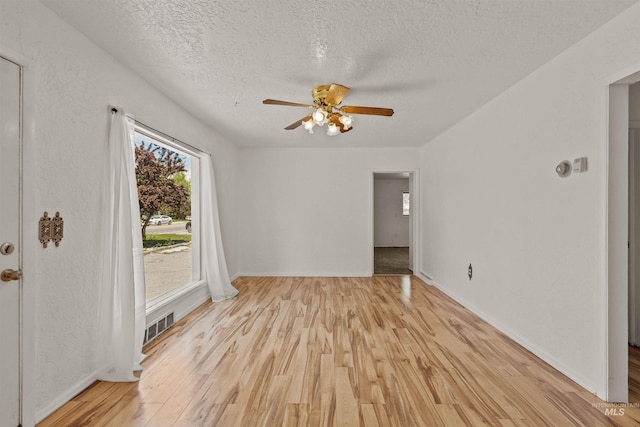 1402 Southside Blvd, Nampa, ID 83686 - empty room featuring a textured ceiling, light wood-style flooring, ceiling fan, and baseboards