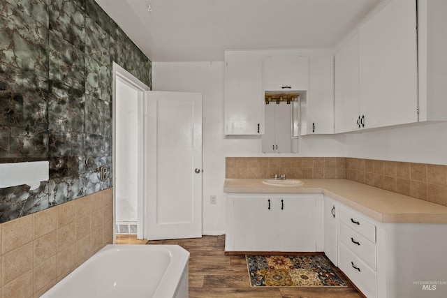 1402 Southside Blvd, Nampa, ID 83686 - kitchen featuring light countertops, white cabinets, a sink, wood finished floors, and decorative backsplash