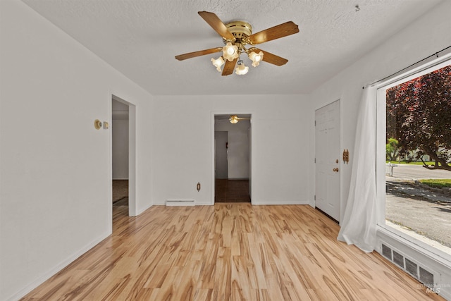 1402 Southside Blvd, Nampa, ID 83686 - spare room featuring a ceiling fan, light wood-type flooring, baseboards, and a textured ceiling