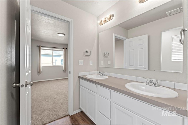 bathroom with vanity, a textured ceiling, and hardwood / wood-style flooring