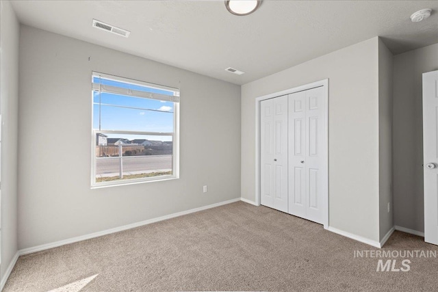 unfurnished bedroom with carpet flooring and a closet