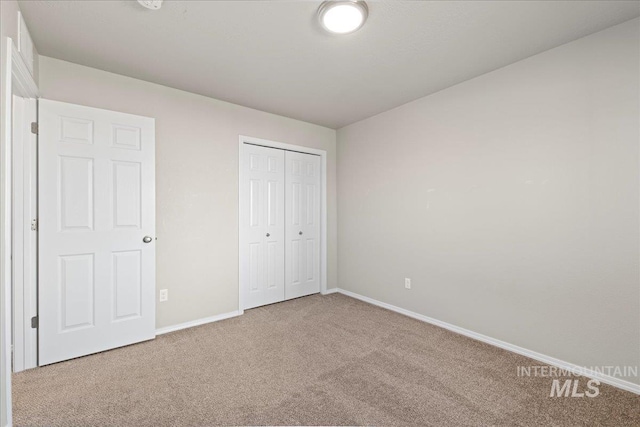 unfurnished bedroom featuring carpet flooring and a closet