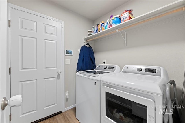 washroom featuring washer and dryer and light hardwood / wood-style floors