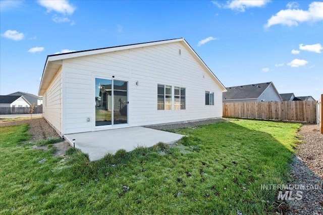 back of house featuring a lawn and a patio