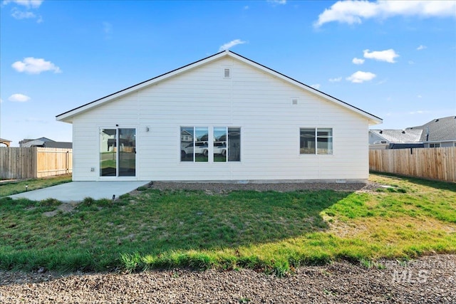 rear view of house featuring a patio area and a lawn