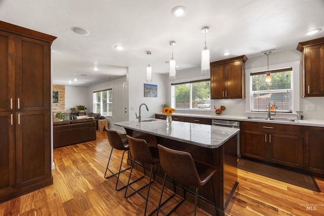 1309 S Pacific St, Boise, ID 83705 - kitchen with light wood finished floors, a breakfast bar area, hanging light fixtures, open floor plan, and stainless steel dishwasher