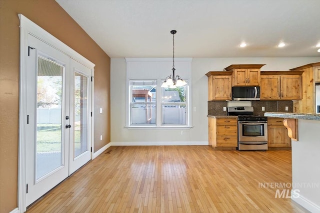 kitchen featuring stainless steel appliances, light wood-type flooring, a chandelier, and recessed lighting