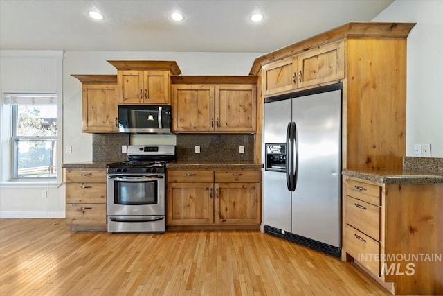 kitchen with stainless steel appliances, light wood-style flooring, decorative backsplash, recessed lighting, and brown cabinets