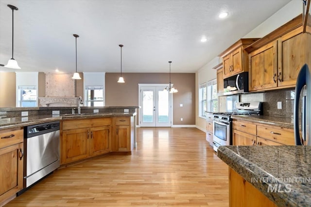 kitchen featuring stainless steel appliances, light wood-type flooring, backsplash, french doors, and recessed lighting