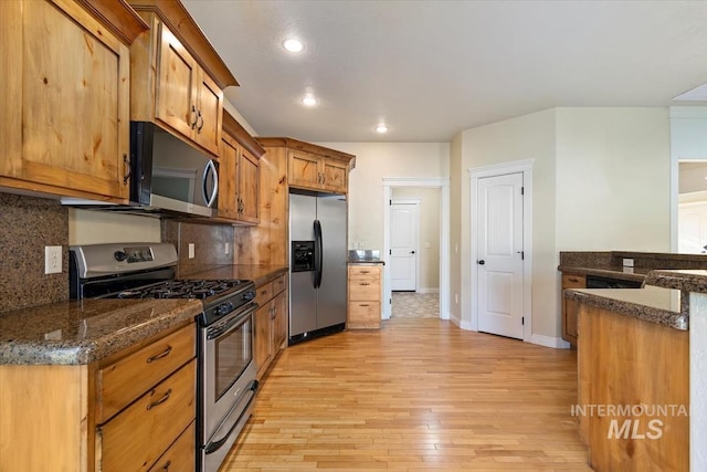 kitchen with appliances with stainless steel finishes, light wood finished floors, decorative backsplash, brown cabinets, and recessed lighting