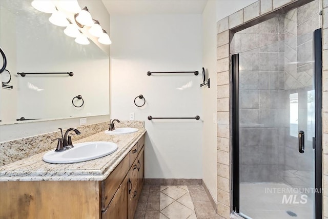 bathroom featuring tile patterned flooring, a stall shower, baseboards, and double vanity