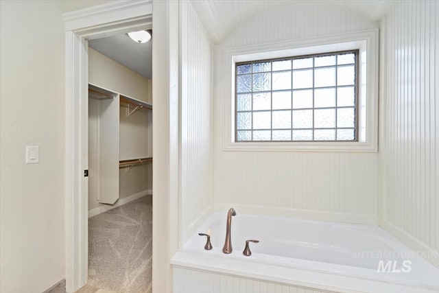 full bathroom with a garden tub and baseboards