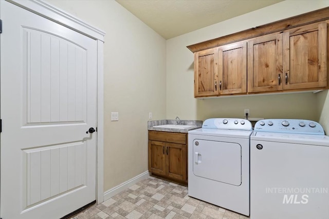 clothes washing area with cabinet space, washing machine and clothes dryer, and baseboards