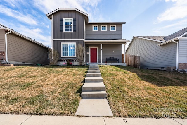 traditional home with board and batten siding, brick siding, fence, and a front lawn