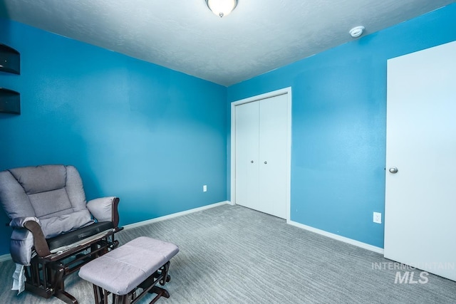 unfurnished room featuring carpet, baseboards, and a textured ceiling