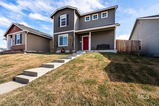 traditional home featuring board and batten siding, a front yard, and fence