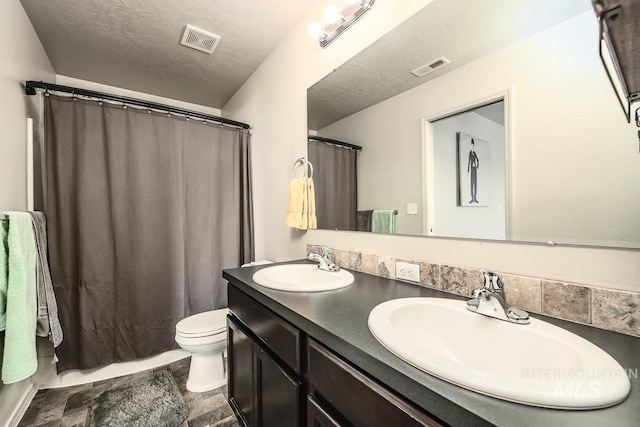 bathroom with toilet, visible vents, and a sink