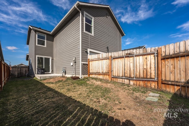 rear view of property with a patio area, a lawn, and a fenced backyard