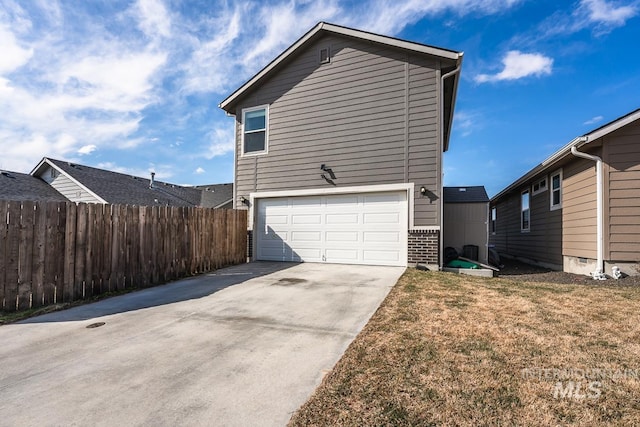 view of home's exterior with a garage, brick siding, fence, concrete driveway, and a lawn