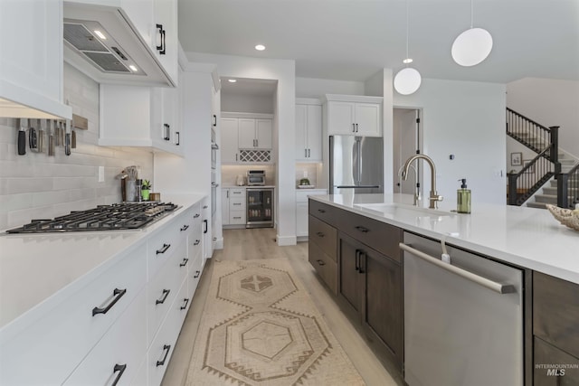 125 S Eagles Roost Way, Eagle, ID 83616 - kitchen featuring appliances with stainless steel finishes, light countertops, white cabinetry, beverage cooler, and dark brown cabinetry