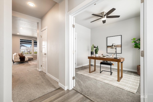 carpeted office space featuring ceiling fan