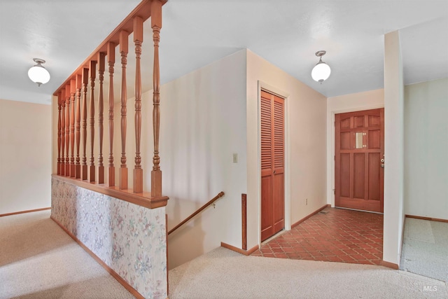 hallway featuring carpet floors and baseboards