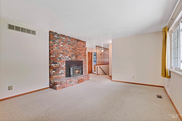 unfurnished living room featuring visible vents, a wealth of natural light, and carpet