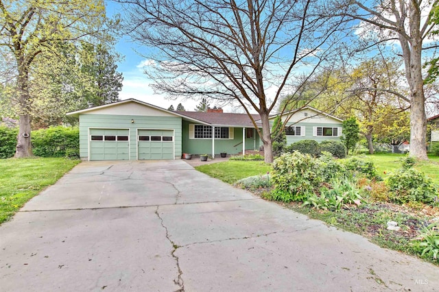 ranch-style home with a garage, a front lawn, driveway, and a chimney