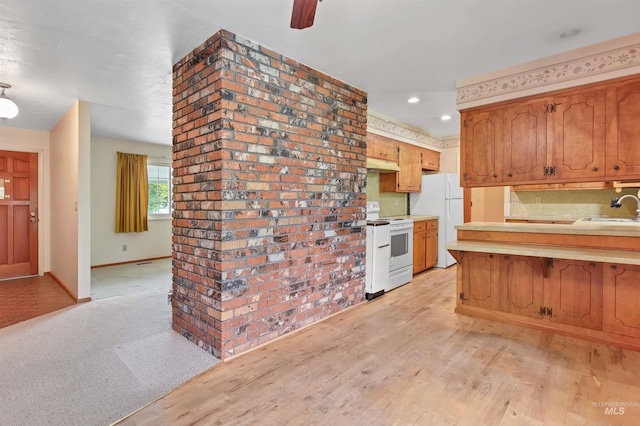 kitchen with a peninsula, white appliances, recessed lighting, light countertops, and under cabinet range hood