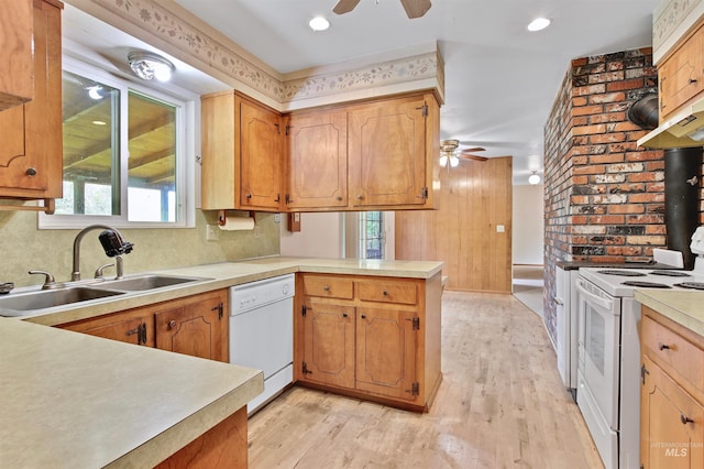 kitchen with a ceiling fan, a sink, a peninsula, white appliances, and light wood-style flooring