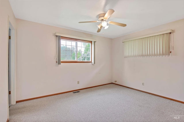 empty room with visible vents, baseboards, carpet floors, and ceiling fan