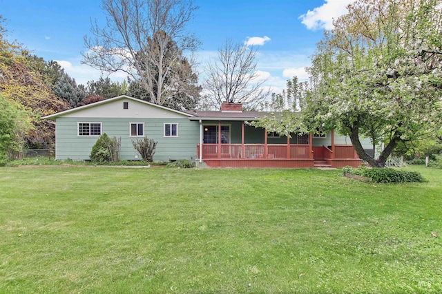 view of front of home with a porch, fence, a chimney, and a front lawn